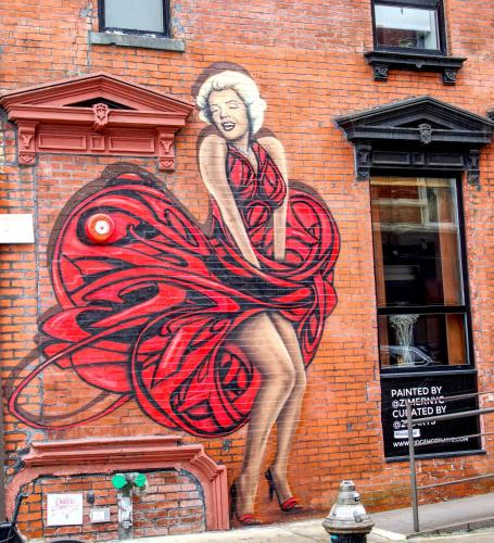 a painting of a woman in a dress on a brick wall at The Ridge in New York