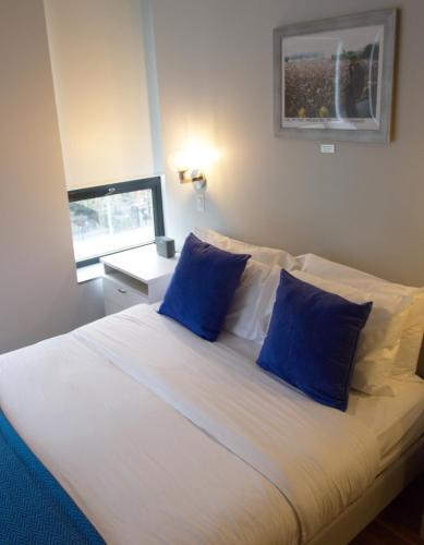 a bedroom with a large bed with blue pillows at The Ridge in New York