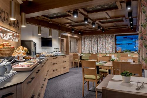 a large kitchen with tables and chairs and a cafeteria at Apart Hotel Garni Wieser in Sölden