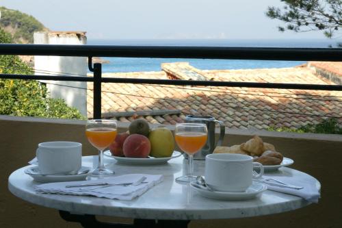 a table topped with plates of food and drinks at Hotel Sa Riera in Begur