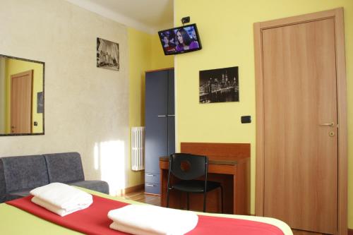 una camera con letto, scrivania e sedia di Hotel America a Milano