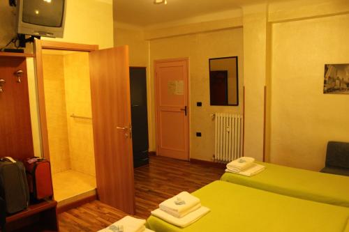 a hotel room with a green bed and a television at Hotel America in Milan