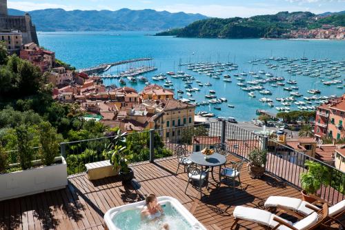 a woman in a hot tub on a balcony overlooking a harbor at Doria Park Hotel in Lerici