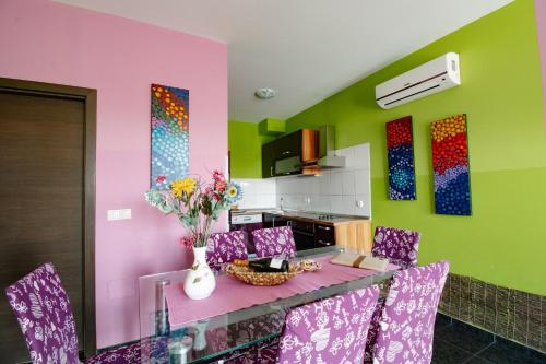 a dining room with a table with purple and green walls at Apartments Pri Adamsovih in Čatež ob Savi