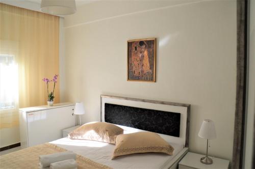 una camera da letto con un letto e un dipinto sul muro di Aigaiou House a Salonicco
