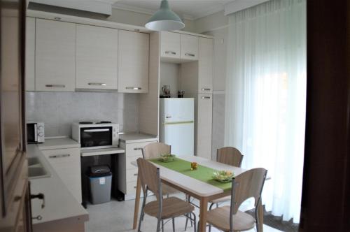 uma cozinha com uma mesa e cadeiras numa cozinha em Aigaiou House em Tessalônica