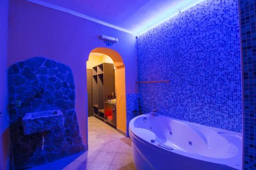 a bathroom with a tub in a purple room at Apartments Pri Adamsovih in Čatež ob Savi