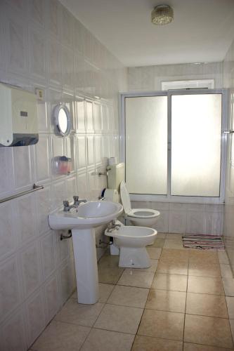 a bathroom with a sink and a toilet and a window at Residencial Rivoli in Fundão