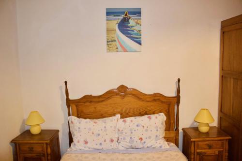 um quarto com uma cama com duas mesas de cabeceira e dois candeeiros em Residencial Rivoli no Fundão