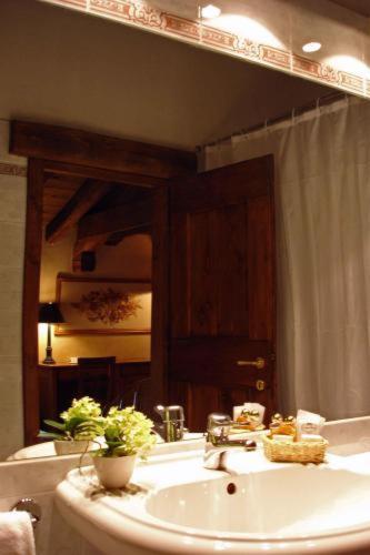 a bathroom with a sink and a large mirror at Hotel L'Ultimo Mulino in Bannia