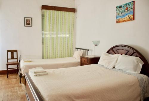 a hotel room with two beds and a window at Residencial Tarouca in Fundão