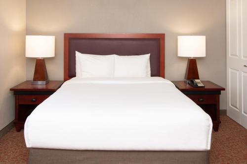 a bedroom with a large bed with two night stands at Larkspur Landing South San Francisco-An All-Suite Hotel in South San Francisco