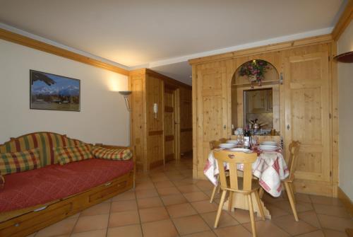 - un salon avec un lit et une table avec des chaises dans l'établissement Front Ski Slope Chamonix Apartment, à Chamonix-Mont-Blanc