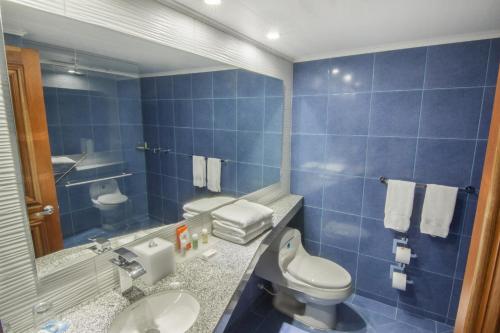 ein blau gefliestes Bad mit WC und Waschbecken in der Unterkunft GHL Hotel Sunrise in San Andrés