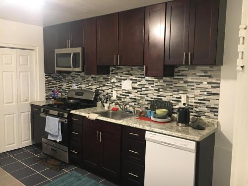 a kitchen with brown cabinets and a sink and a stove at GORGEOUS HOUSE NEXT JHU in Baltimore
