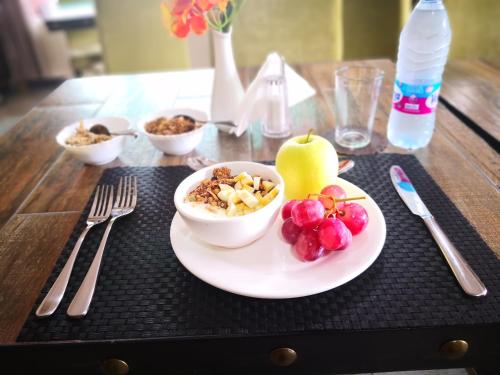 a table with a bowl of cereal and fruit on a plate at Frederick's Lodge in Kumasi