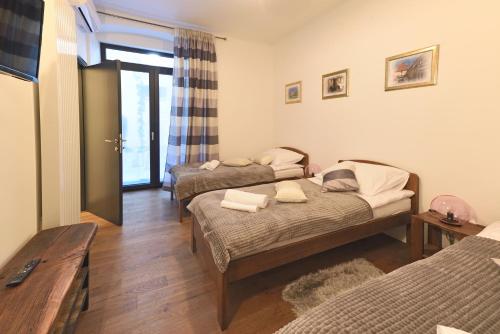 sypialnia z 2 łóżkami i drewnianą podłogą w obiekcie Apartment Rest in The Best w Zagrzebiu