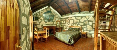 a bedroom with a bed in a stone wall at Hotel Mansion Tarahumara in Areponapuchi