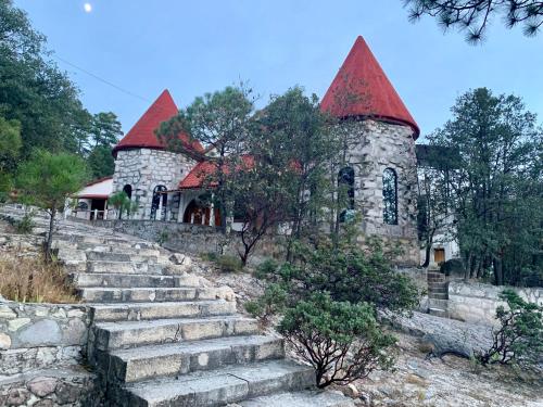 a stone building with red roofs on a hill at Hotel Mansion Tarahumara in Areponapuchi