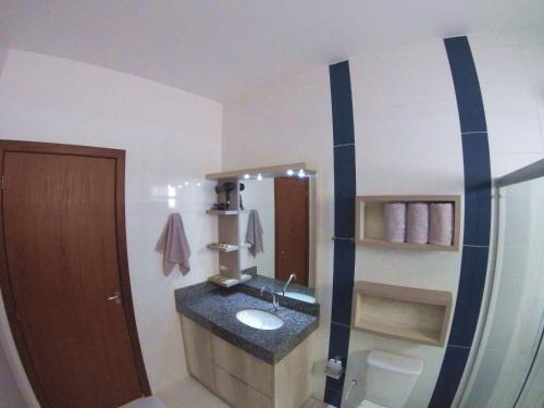 a bathroom with a sink and a mirror at Pousada Origin in Guarda do Embaú