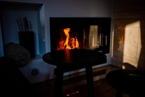 a fireplace with a table in front of it with a fire at Winiec Family Houses in Winiec