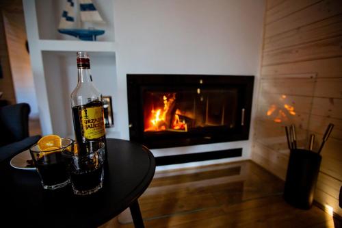 a bottle of wine on a table in front of a fireplace at Winiec Family Houses in Winiec