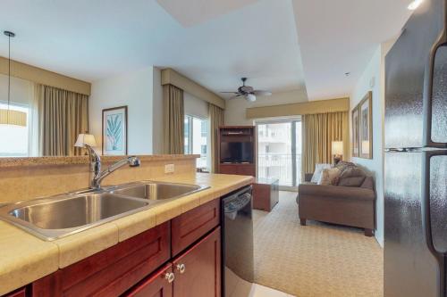 a kitchen with a sink and a living room at Luau Condos in Destin