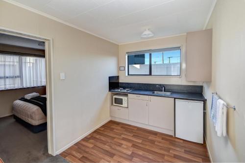 una cocina vacía con fregadero y ventana en ASURE Adrian Motel, en Dunedin