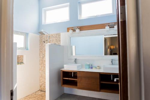 Baño con 2 lavabos y espejo en Malmok Beach Break Villa, en Palm-Eagle Beach