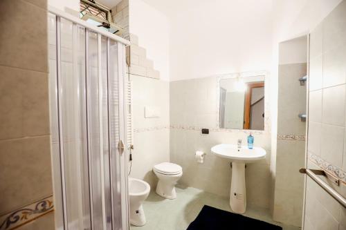 a white bathroom with a toilet and a sink at La casa di Zucca sopra piazza Plebiscito! in Naples