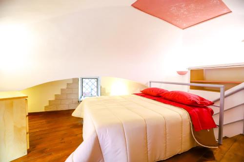 a bedroom with a bed with red pillows on it at La casa di Zucca sopra piazza Plebiscito! in Naples