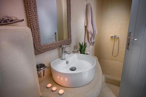 a bathroom with a white sink and a mirror at Simousi Villas in Kithnos