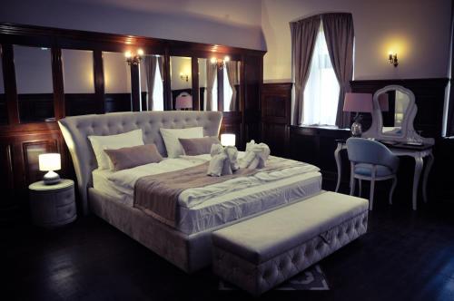 a bedroom with a bed with two teddy bears on it at Belga Boutique Panzió in Debrecen