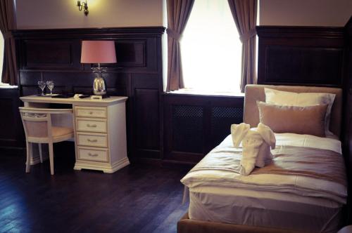 a bedroom with a bed with a desk and a bed sidx sidx sidx at Belga Boutique Panzió in Debrecen