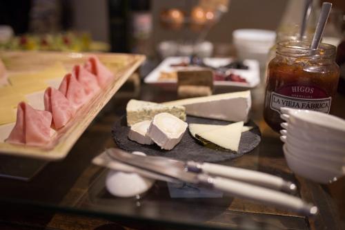 a table topped with plates of cheese and sauce at Hotel Abaco Altea in Altea
