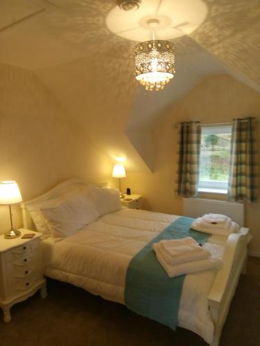 1 dormitorio con cama y lámpara de araña en Garroch House en Carbost