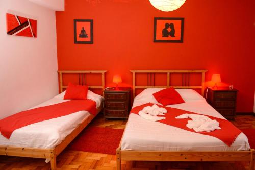 two beds in a room with red walls at SEIA Apartamentos Serra da Estrela in Seia