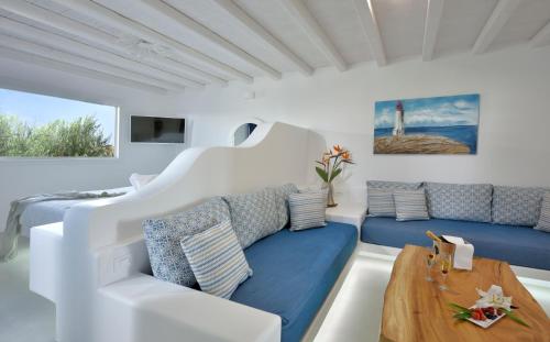 a white living room with blue couches and a table at AC Village Christoulis in Mýkonos City