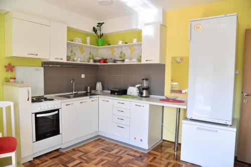 a kitchen with white appliances and yellow walls at Apartment with free parking Marija in Niš