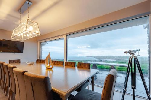 a dining room with a table and a large window at Ocean View,Kinsale, Hosted by Exquisite holiday homes, sleeps 22 in Kinsale