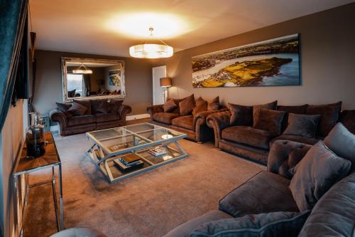 a living room with couches and a glass table at Ocean View,Kinsale, Hosted by Exquisite holiday homes, sleeps 22 in Kinsale