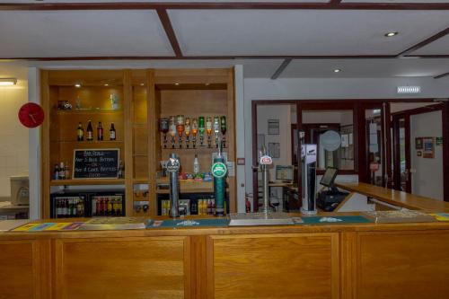 a bar in a room with a counter with alcohol at Primelodge Rotherham in Hellaby