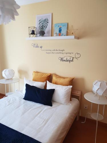 a bedroom with a bed with white sheets and pillows at DOWNTOWN-Guest House in Olhão
