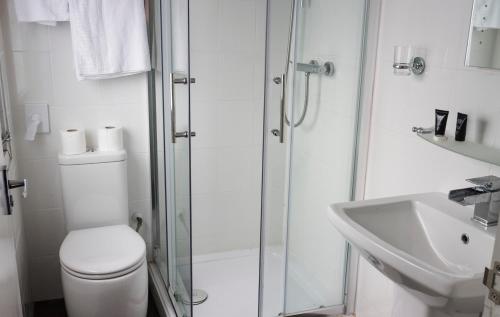 a bathroom with a shower and a toilet and a sink at Primelodge Doncaster in Doncaster