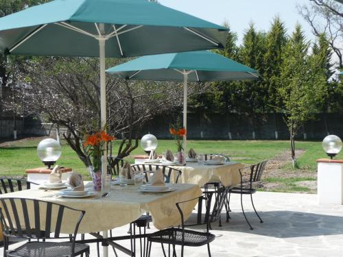 a group of tables with chairs and umbrellas at Hotel Finca Las Hortensias in Tepotzotlán