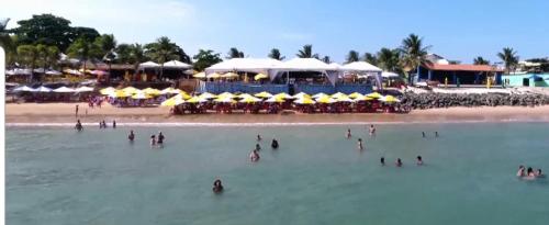 a group of people in the water at a beach at Genipabu Summer House Guarajuba in Guarajuba