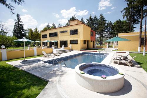 een achtertuin met een zwembad en een huis bij Hotel Finca Las Hortensias in Tepotzotlán
