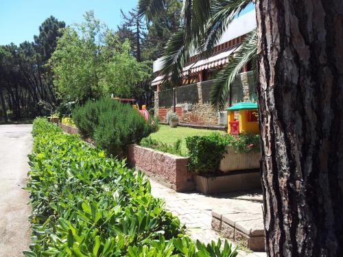 a house with a garden with a toy sprinkler at Hotel Grifone in Principina a Mare