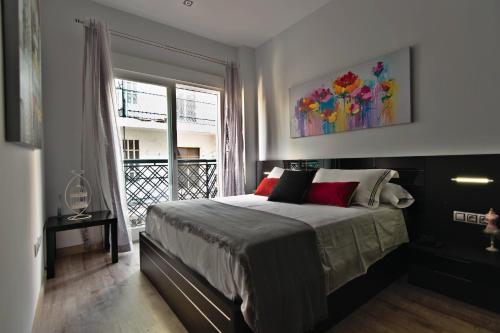 um quarto com uma cama com um quadro na parede em apartamento completo centrico em Maracena