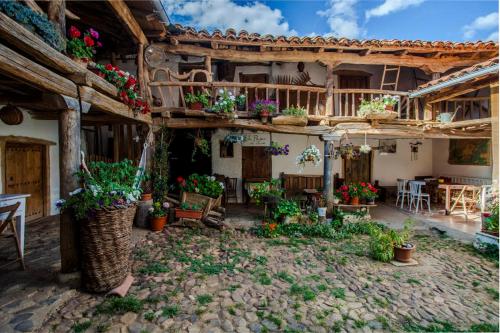 a courtyard of a house with potted plants at El Pajar de Oncina Albergue Peregrinos in Oncina de la Valdoncina
